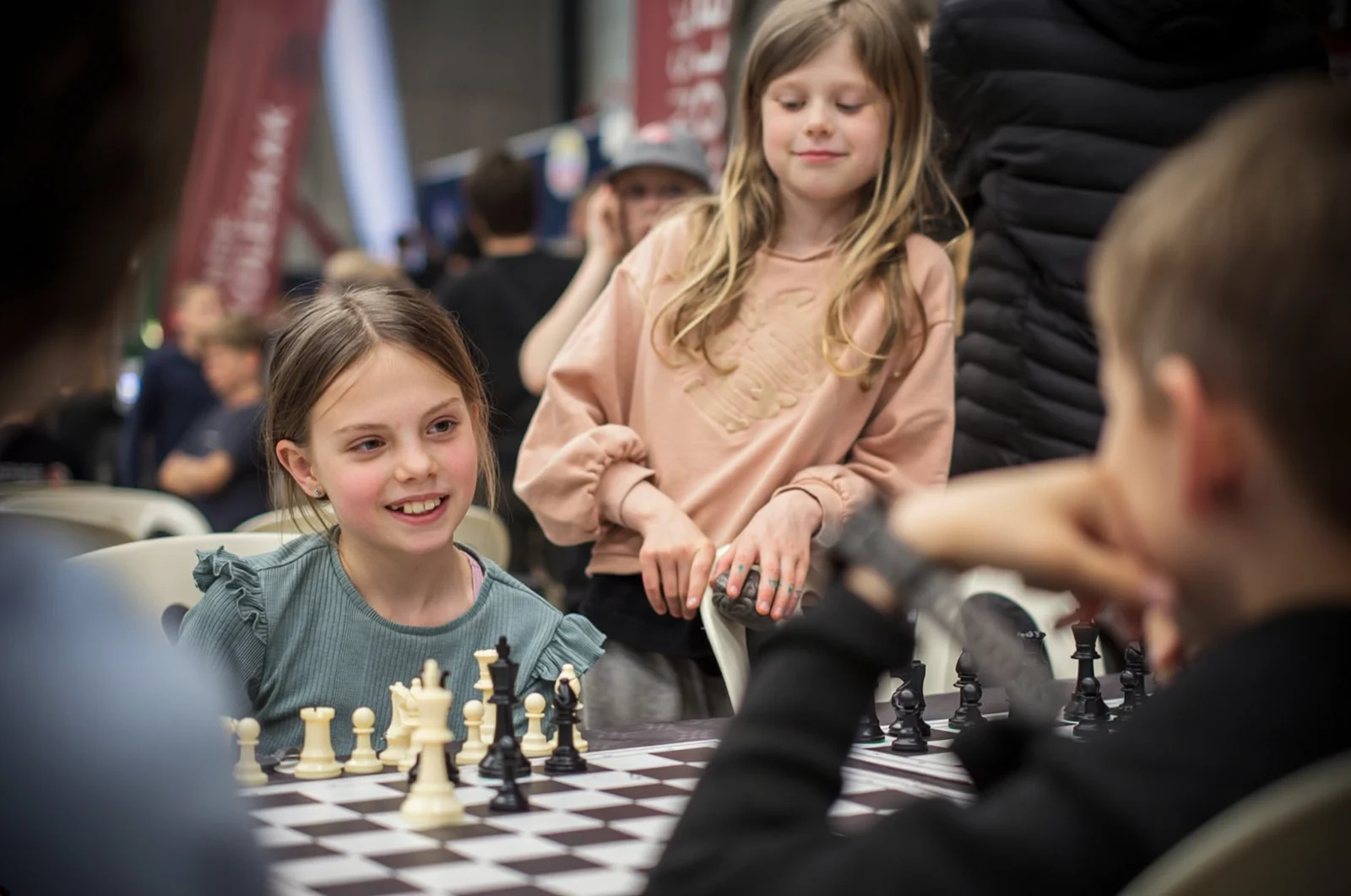 Children gathered around a chessboard during a school learning activity.
