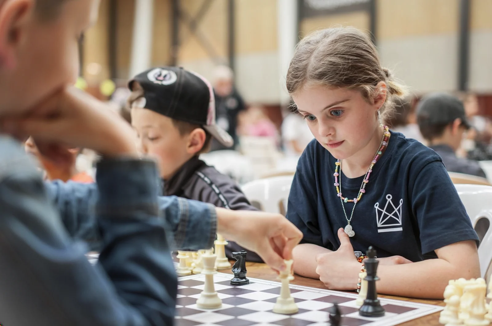 Children concentrating on a chess game during a learning activity.