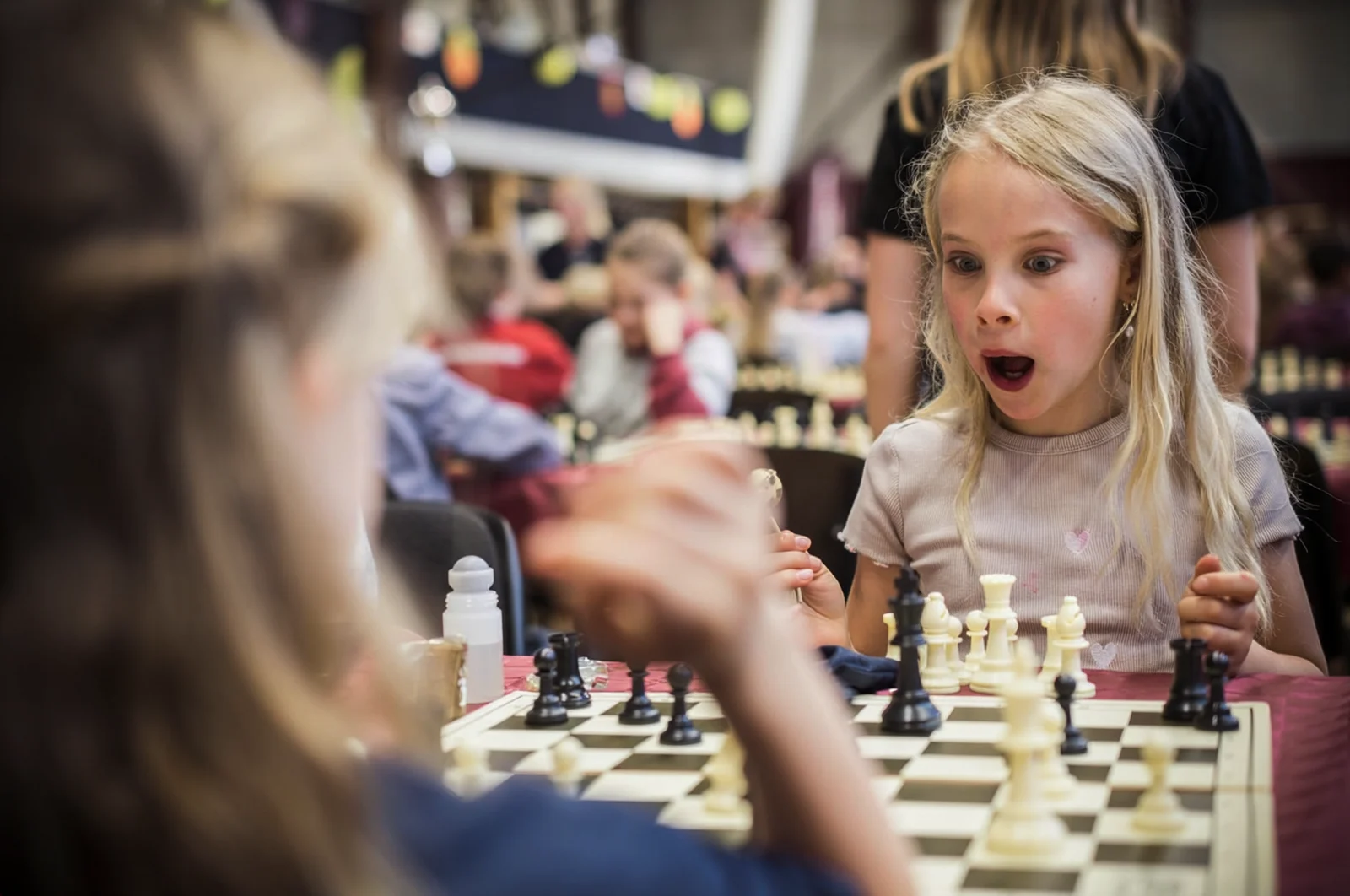 A child reacting with excitement during a chess-based learning activity.